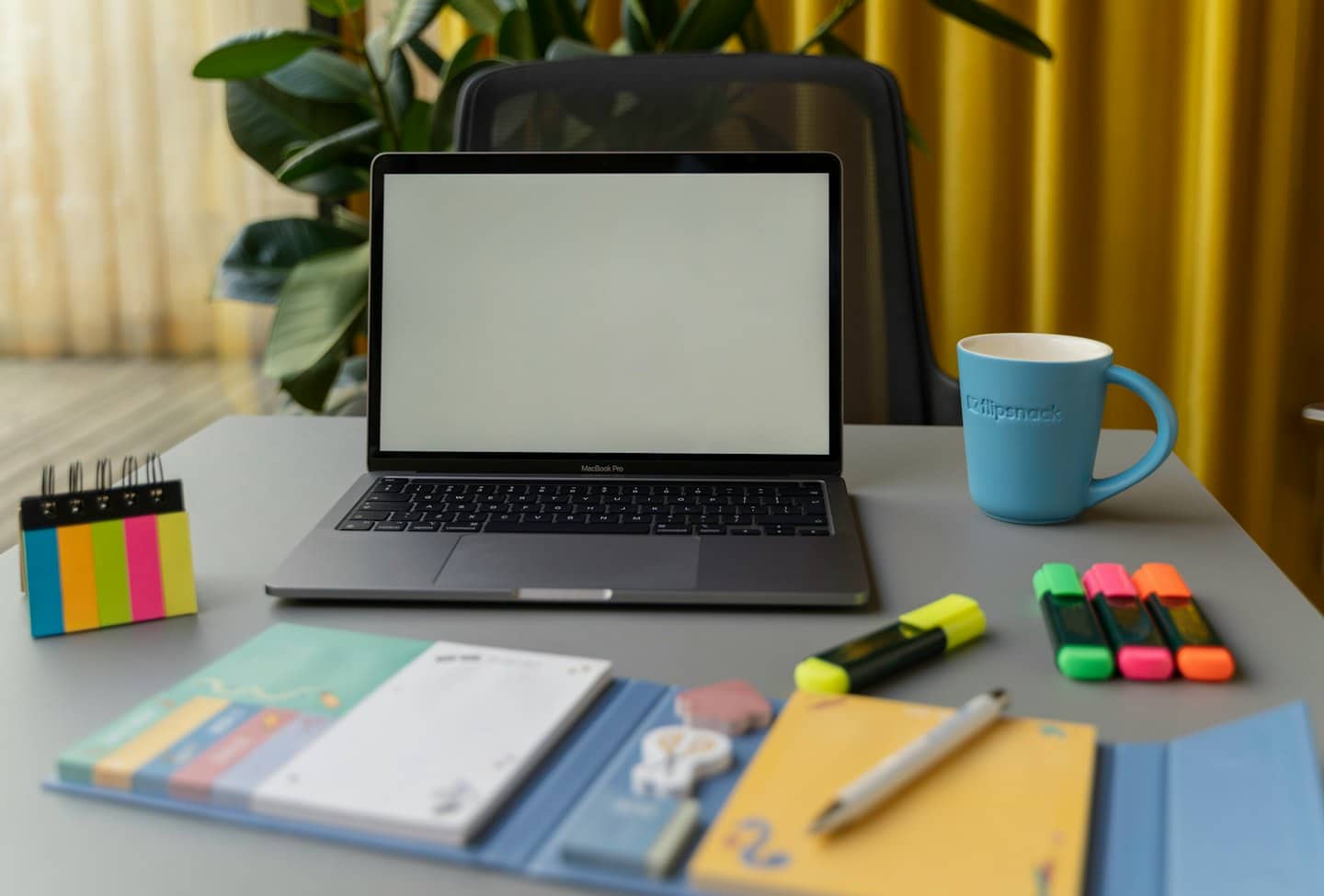 Open laptop and office supplies on a desk.