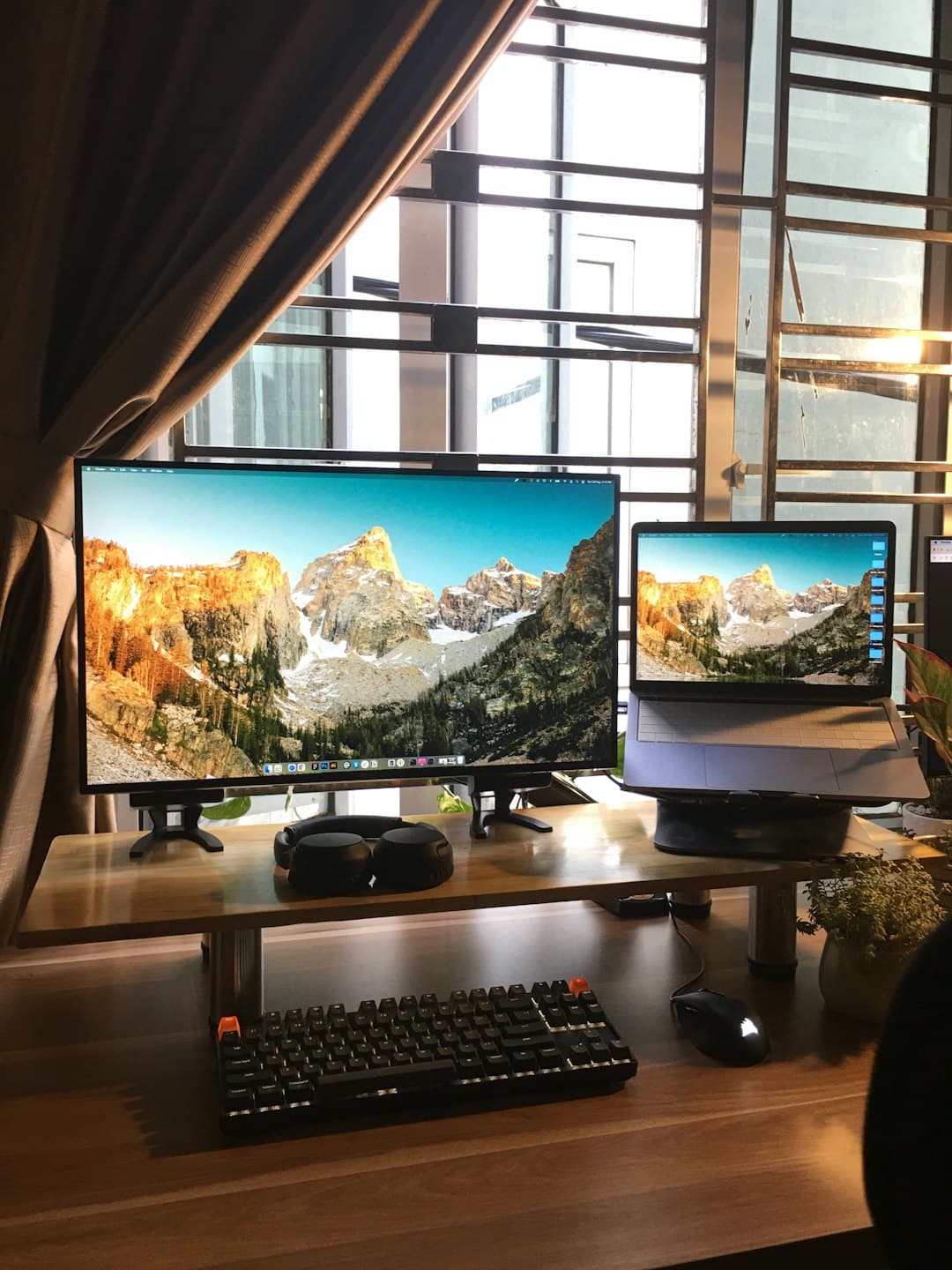 A computer setup with a laptop and monitor on a desk.